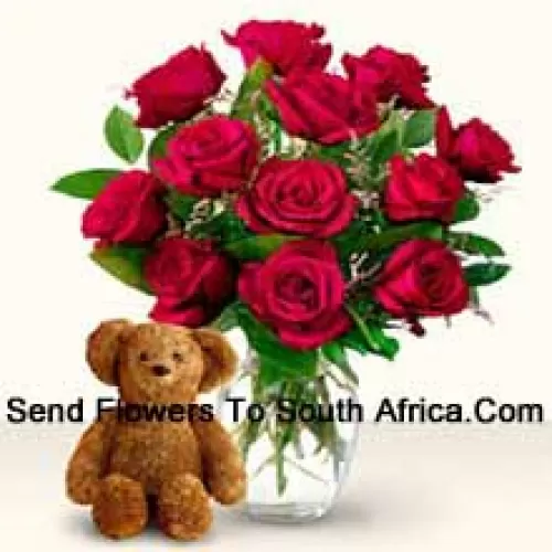 12 roses rouges avec des fougères dans un vase en verre accompagnées d'un mignon ours en peluche brun de 12 pouces de hauteur