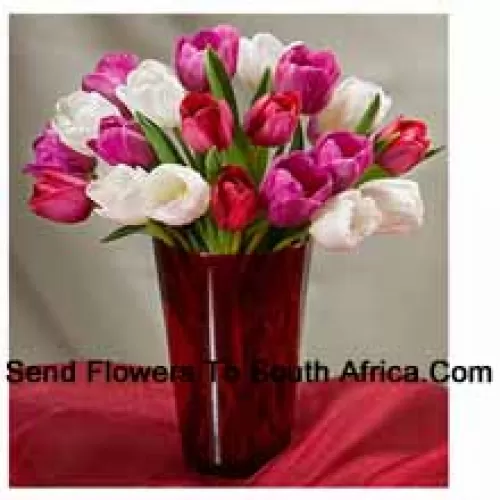 Tulipes colorées mélangées avec des remplisseurs saisonniers dans un vase en verre - Veuillez noter que en cas de non disponibilité de certaines fleurs saisonnières, celles-ci seront substituées par d'autres fleurs de même valeur