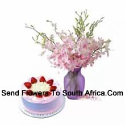 Orchidées fraîches dans un vase accompagnées d'un gâteau aux fraises d'un demi-kilo